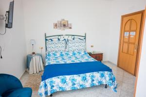 a bedroom with a bed with a blue and white bedspread at Villa Bianca in Tramonti