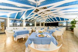 a dining room with blue tables and white chairs at Hotel Santa Caterina in Palinuro