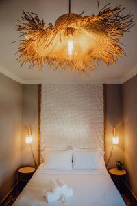 a bedroom with a bed and a chandelier at Quinta Dos Avós Lourenço in Sertã