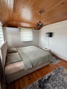 1 dormitorio con cama y techo de madera en GÖKTÜRK APART, en Trabzon