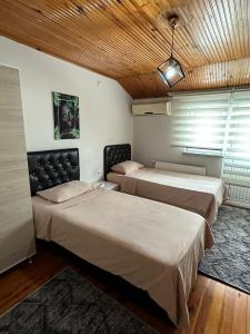 a bedroom with two beds and a wooden ceiling at GÖKTÜRK APART in Trabzon