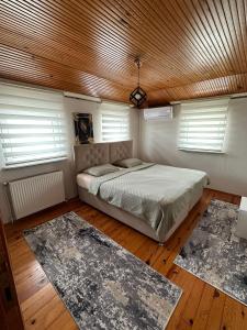 a bedroom with a bed and two rugs at GÖKTÜRK APART in Trabzon