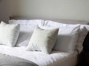 a white bed with four pillows on it at Appartamento Le tre finestre in La Spezia