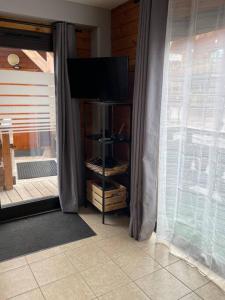 uma sala de estar com uma televisão e uma janela em Duplex dans chalet au coeur de la station em Réallon