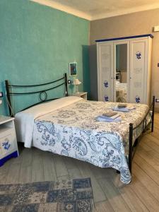 a bedroom with a bed with a blue and white comforter at L'Incantesimo in Triora