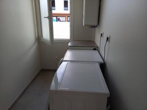 une petite cuisine avec deux lavabos et une fenêtre dans l'établissement CAMPING PARADIS Domaine Oyat, à Le Fenouiller