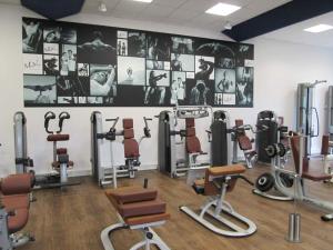 une salle de sport avec de nombreux équipements d'exercice sur un mur dans l'établissement Thermalhotel Kemper, à Erwitte