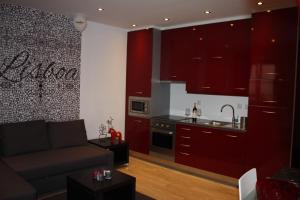 a kitchen with red cabinets and a couch in a living room at Live Alfama in Lisbon