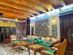 a living room with couches and tables at Hotel Nurafshon Boutique in Bukhara