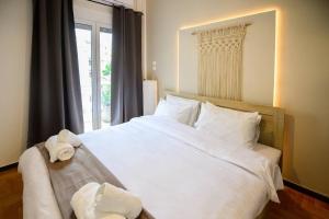 een slaapkamer met een groot wit bed en een raam bij Boho Luxury 2 BR Apartment, Acropolis Museum View in Athene