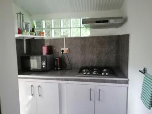 a kitchen with white cabinets and a stove top oven at koeuris apartment in La Gaulette