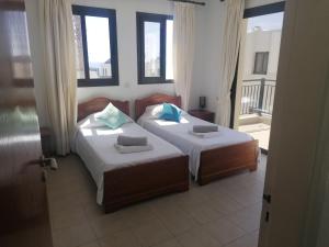 - 2 lits dans une chambre avec 2 fenêtres dans l'établissement Villa Med-Sunset, à Kissonerga