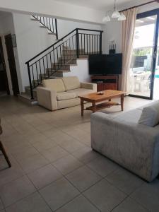 Una sala de estar con un sofá y un piano. en Villa Med-Sunset, en Kissonerga