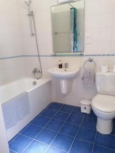 La salle de bains est pourvue de toilettes blanches, d'un lavabo et d'une baignoire. dans l'établissement Villa Med-Sunset, à Kissonerga