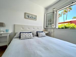 ein weißes Schlafzimmer mit einem großen Bett und einem Fenster in der Unterkunft Beach Cottage in Maspalomas + 38 Fotos