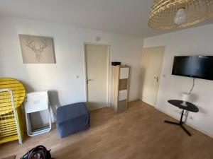 a room with a bed and a table and a tv at Appartement jusqu'à 4 personnes in Luchon