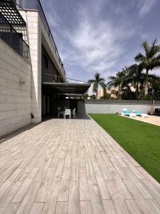 a large building with a patio and a lawn at Luxury garden floor Eilat in Eilat
