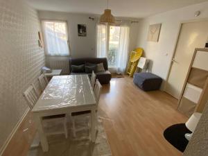 a living room with a table and a couch at Appartement jusqu'à 4 personnes in Luchon