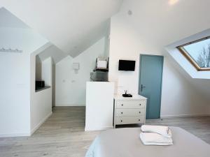 Dormitorio blanco en el ático con cama y ventana en Onyx d'Opale, en Calais