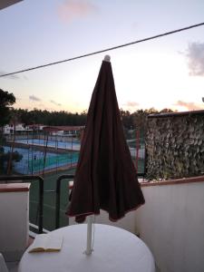 una sombrilla cerrada sobre una mesa en un balcón en Casa vacanze La Marinella, en SantʼEufemia Lamezia