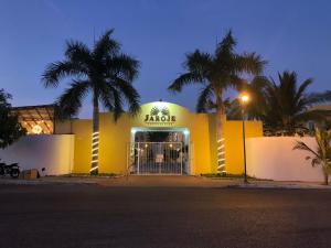 ein gelbes Gebäude mit Palmen davor in der Unterkunft Condominios JAROJE Huatulco in Santa Cruz Huatulco