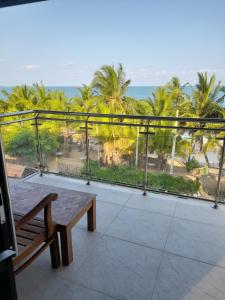 balcón con banco y vistas al océano en Shanika Beach Inn, en Tangalle