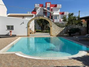 a swimming pool in front of a building at Hotel Rainbow Resort in Marsala