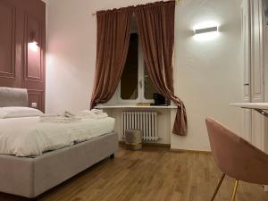 a bedroom with a bed and a chair in it at Turin Central Suite in Turin