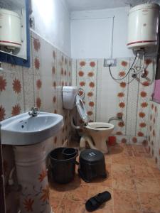 a bathroom with a sink and a toilet at Hotel Happy Home in Srinagar