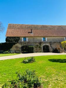 a large stone house with a green lawn in front of it at Domaine de Montanty in Gramat