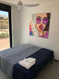 sypialnia z łóżkiem i obrazem na ścianie w obiekcie Deluxe VILLA LAVANDA Las Colinas DEHESA DE CAMPOAMOR with HEATED POOL w mieście Campoamor