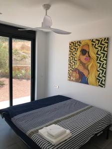 sypialnia z łóżkiem i obrazem na ścianie w obiekcie Deluxe VILLA LAVANDA Las Colinas DEHESA DE CAMPOAMOR with HEATED POOL w mieście Campoamor +37 zdjęć