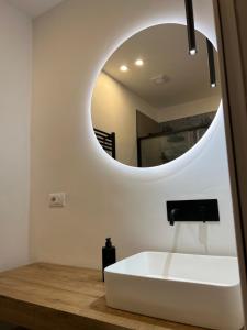 uma casa de banho com um lavatório branco e um espelho. em Turin Central Suite em Turim