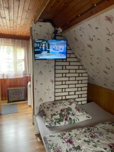 a bedroom with a bed and a tv on the wall at Chata Dagmar in Třebíč