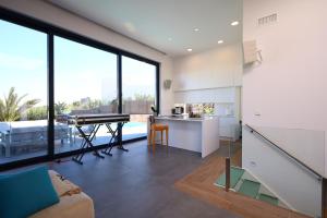 kuchnia i salon z fortepianem w obiekcie Deluxe VILLA LAVANDA Las Colinas DEHESA DE CAMPOAMOR with HEATED POOL w mieście Campoamor