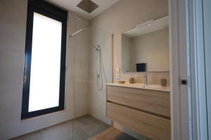 łazienka z prysznicem, umywalką i lustrem w obiekcie Deluxe VILLA LAVANDA Las Colinas DEHESA DE CAMPOAMOR with HEATED POOL w mieście Campoamor