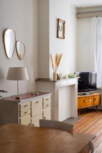 a living room with a table and a tv at Ruime woning in een leuke buurt nabij het centrum in Antwerp