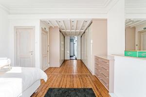 een slaapkamer met een wit bed en een houten vloer bij Ruime woning in een leuke buurt nabij het centrum in Antwerpen