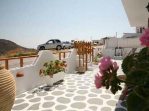 a balcony with potted plants and a car in the background at Andreas and Petrinela Rooms in Triovasálos