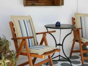 two chairs and a table in a room with a table at Andreas and Petrinela Rooms in Triovasálos
