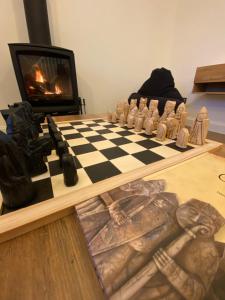 um tabuleiro de xadrez numa mesa com lareira em Kinnoull House near Stornoway Hot Tub/Pet Friendly em Garrabost