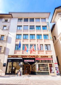 un hôtel avec drapeaux devant un bâtiment dans l'établissement Hotel San Carlo, à Lugano