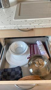 a drawer with plates and pans in a kitchen at Studio Moderne au Victor Hugo in Les Mureaux