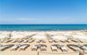 a beach with chairs and umbrellas and the ocean at Amazing Apartment In Agropoli With Wifi in Agropoli +40 photos