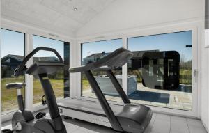 Gorgeous Home In Hadsund With Sauna في Øster Hurup: صالة ألعاب رياضية مع دراجتين تمرين أمام النافذة