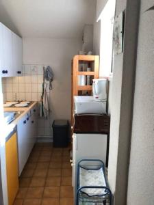 eine kleine Küche mit weißen Schränken und einem Kühlschrank in der Unterkunft Appartement TY DANY , 150m de la plage in Carnac