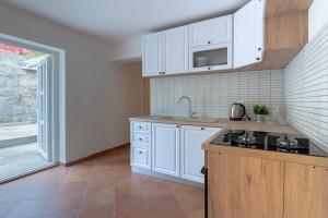 a kitchen with white cabinets and a counter top at Casa Bella in Karlobag