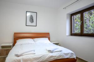 a bedroom with a bed with white sheets and a window at Casa Bella in Karlobag