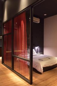 een slaapkamer met een bed met rode gordijnen bij The Label Suites Ipoh in Ipoh