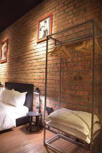 a brick bedroom with a bunk bed and a brick wall at The Label Suites Ipoh in Ipoh